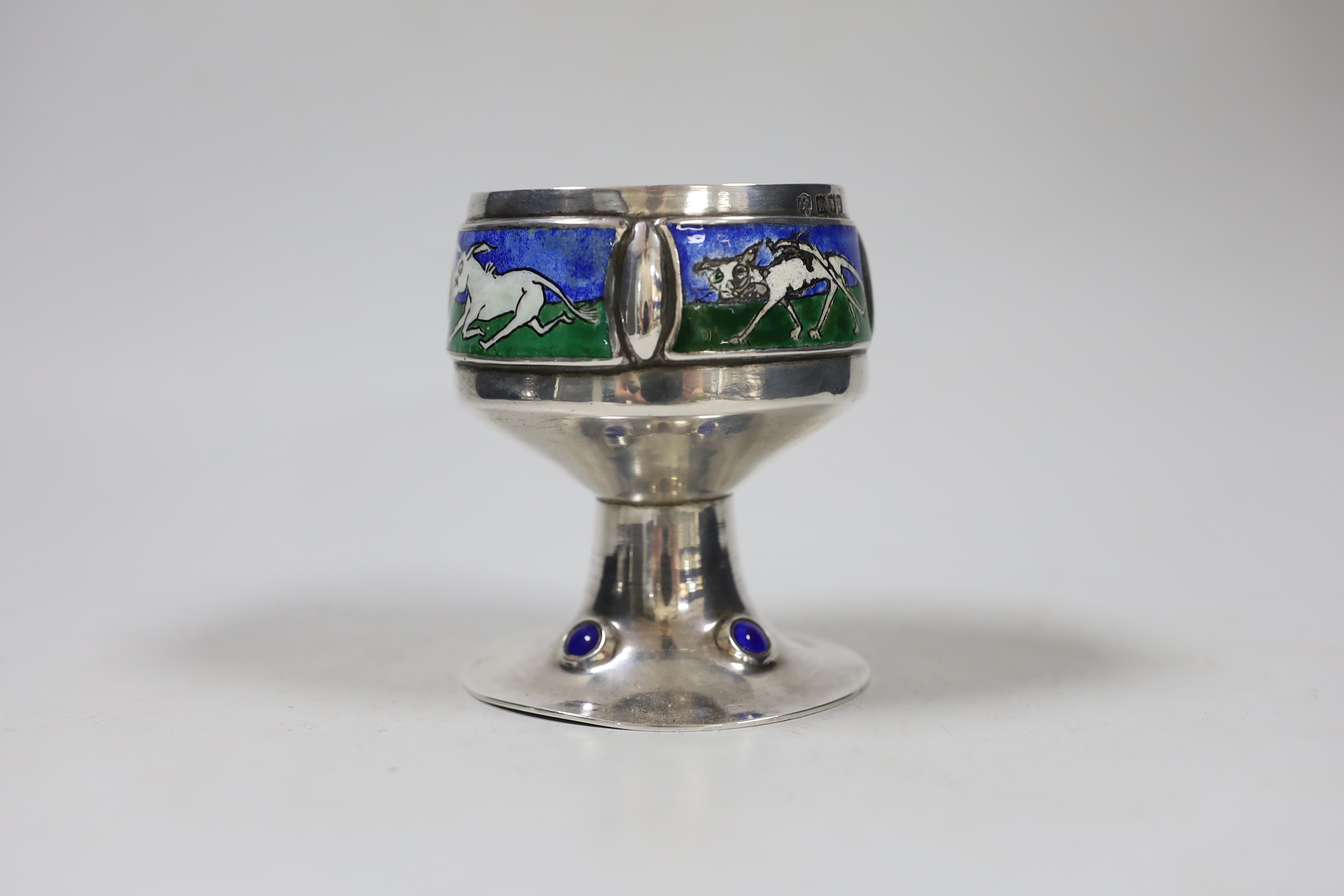 An Edwardian Arts and Crafts silver and enamel chalice, overstamped maker's mark, London, 1902, height 9.3cm, decorated with animals, on a beaded foot, gross 9.6oz.